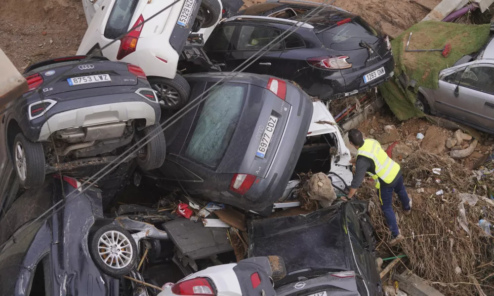 A civil guard seaches for survivors in cars piled up on the outskirts of Valencia, Spain, Friday, Nov. 1, 2024 after flooding. (AP Photo/Alberto Saiz)