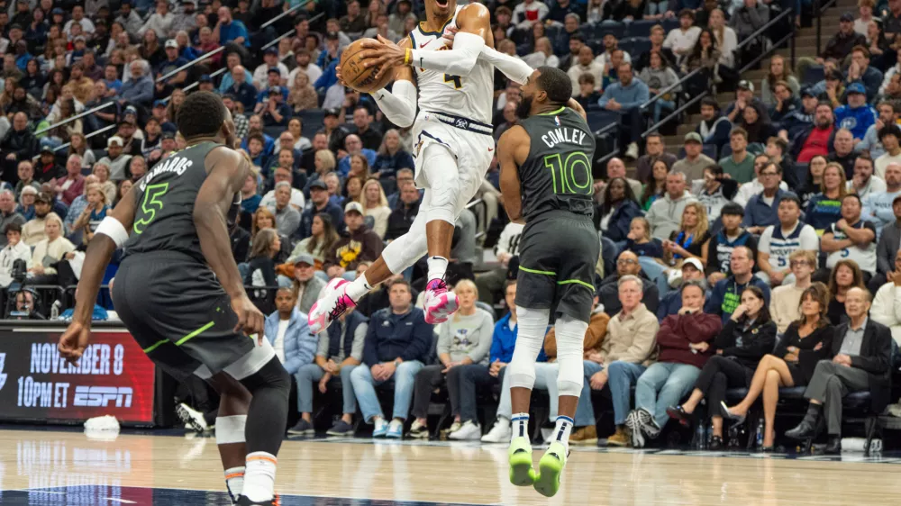 Nov 1, 2024; Minneapolis, Minnesota, USA; Denver Nuggets guard Russell Westbrook (4) shoots over Minnesota Timberwolves guard Mike Conley (10) in the fourth quarter at Target Center. Mandatory Credit: Matt Blewett-Imagn Images