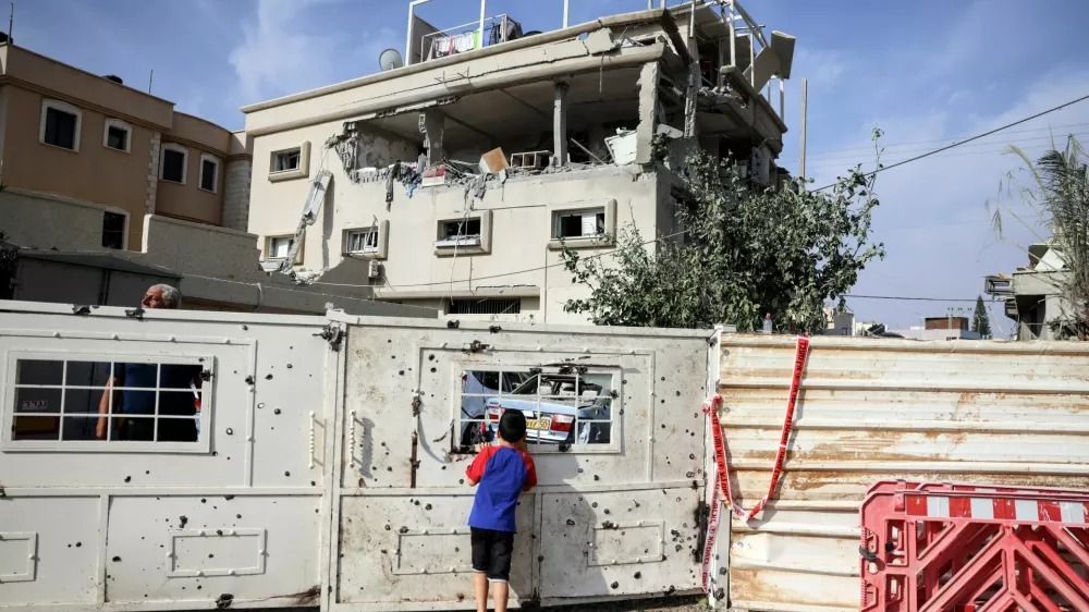 A boy looks through the gate to a house that was hit, following a projectiles attack from Lebanon towards Israel, amid cross-border hostilities between Hezbollah and Israel, in the central Israeli town of Tira, November 2, 2024. REUTERS/Moti Milrod ISRAEL OUT. NO COMMERCIAL OR EDITORIAL SALES IN ISRAEL