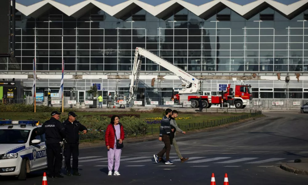 People walk by as a rescue team inspects the area where a part of a roof of a railway station collapsed in Novi Sad, Serbia November 2, 2024. REUTERS/Marko Djurica