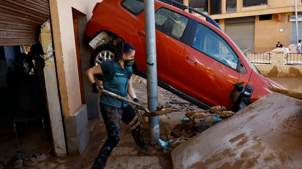 A Spanish Civil Guard who came from Teruel as a volunteer helps remove mud from a home in the aftermath of floods caused by heavy rains, in Alfafar, near Valencia, Spain, November 2, 2024. REUTERS/Susana Vera REFILE - QUALITY REPEAT