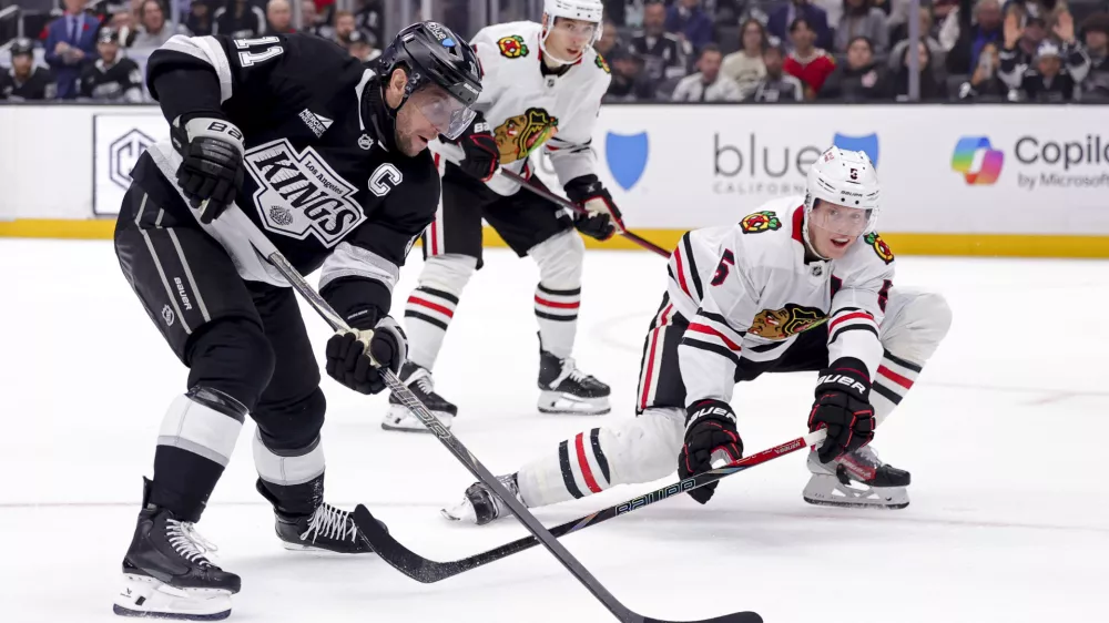 Los Angeles Kings center Anze Kopitar, left, controls the puck against Chicago Blackhawks defenseman Connor Murphy during the second period of an NHL hockey game, Saturday, Nov. 2, 2024, in Los Angeles. (AP Photo/Ryan Sun)