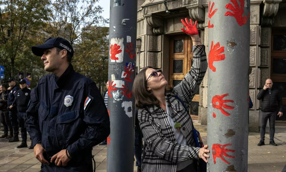 Members of police stand guard as a demonstrator protests to commemorate an accident at a railway station in the Serbian city of Novi Sad, for which they blame negligence and corruption by the authorities, in front of the government in Belgrade, Serbia November 3, 2024. REUTERS/Marko Djurica