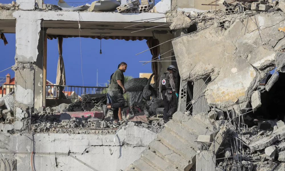 Rescue workers search for victims at a destroyed building hit in an Israeli airstrike, in Ghaziyeh town, south Lebanon, Sunday, Nov. 3, 2024. (AP Photo/Mohammed Zaatari)