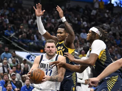 Nov 4, 2024; Dallas, Texas, USA; Dallas Mavericks guard Luka Doncic (77) drives to the basket between Indiana Pacers guard Bennedict Mathurin (00) and center Myles Turner (33) during the second half at the American Airlines Center. Mandatory Credit: Jerome Miron-Imagn Images