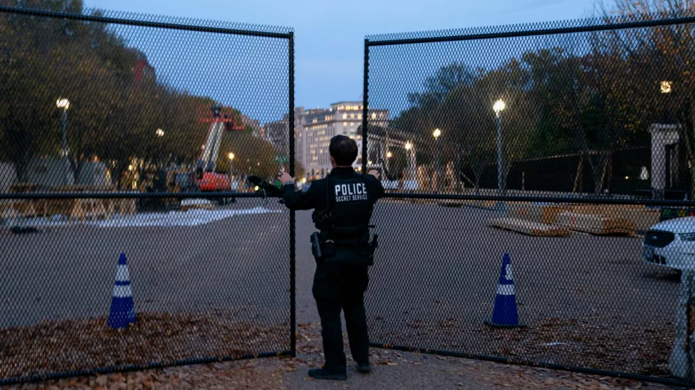 A member of the U.S. Secret Service closes a security gate along Pennsylvania Avenue near the White House on the day before the U.S. presidential election in Washington, U.S., November 4, 2024. REUTERS/Nathan Howard