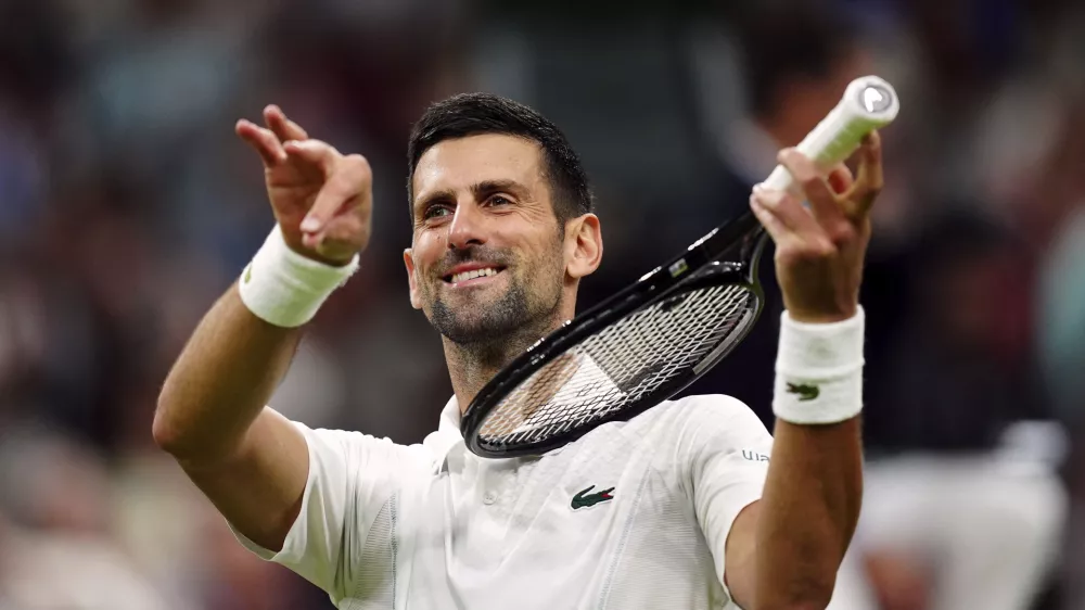 Novak Djokovic of Serbia pretends to play a violin after defeating Holger Rune of Denmark in their fourth round match at the Wimbledon tennis championships in London, Monday, July 8, 2024. (Mike Egerton/PA via AP)