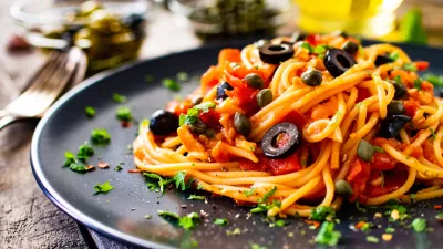 Pasta puttanesca with tomato sauce, anchovies, chilli, capers and olives on wooden table / Foto: Gbh007