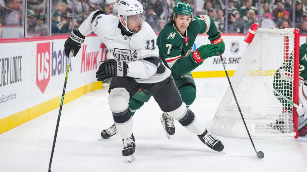 Nov 5, 2024; Saint Paul, Minnesota, USA; Los Angeles Kings center Anze Kopitar (11) skates after the puck against the Minnesota Wild defenseman Brock Faber (7) in the first period at Xcel Energy Center. Mandatory Credit: Brad Rempel-Imagn Images