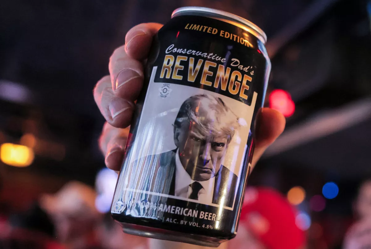 A supporter of Republican presidential nominee former U.S. President Donald Trump holds a limited edition beer with an image of Trump and the words "Conservative Dad's Revenge", as he attends the New York Young Republican Club watch party during the 2024 U.S. presidential election, in Manhattan, New York City, U.S., November 6, 2024. REUTERS/Andrew Kelly