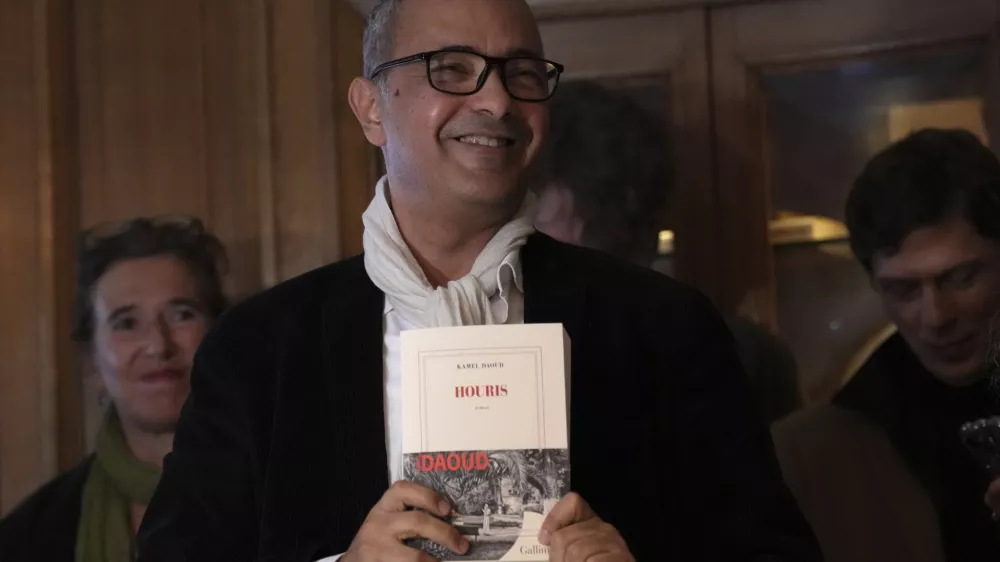 Algerian-French novelist Kamel Daoud holds his book Houris after being awarded with the Goncourt, France's most prestigious literary prize, Monday, Nov. 4, 2024 in Paris. (AP Photo/Aurelien Morissard)