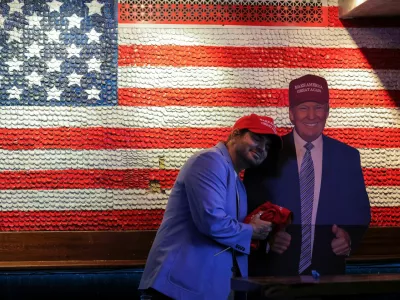 A supporter of Republican presidential nominee former U.S. President Donald Trump embraces a cardboard cut-out of Trump as he reacts to election results while attending the New York Young Republican Club watch party during the 2024 U.S. presidential election, in Manhattan, New York City, U.S., November 6, 2024. REUTERS/Andrew Kelly