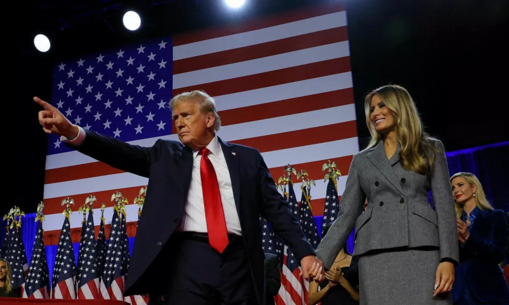 Republican presidential nominee and former U.S. President Donald Trump gestures as he holds hands with his wife Melania during his rally, at the Palm Beach County Convention Center in West Palm Beach, Florida, U.S., November 6, 2024. REUTERS/Brian Snyder   TPX IMAGES OF THE DAY