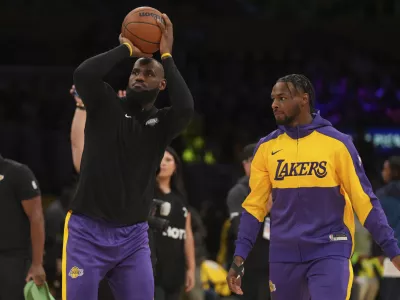 Los Angeles Lakers forward LeBron James, left, and guard Bronny James warm up before an NBA basketball game against the Minnesota Timberwolves, Tuesday, Oct. 22, 2024, in Los Angeles. (AP Photo/Eric Thayer)