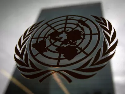 FILE PHOTO: The United Nations headquarters building is pictured though a window with the UN logo in the foreground in the Manhattan borough of New York August 15, 2014. REUTERS/Carlo Allegri/File Photo