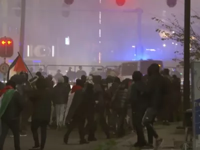 In this image taken from video, a group of pro-Palestinian protesters walk toward police line, with police vans driving in the background, near the soccer stadium in Amsterdam, Netherlands, Thursday, Nov. 7, 2024. (RTL Nieuws via AP)