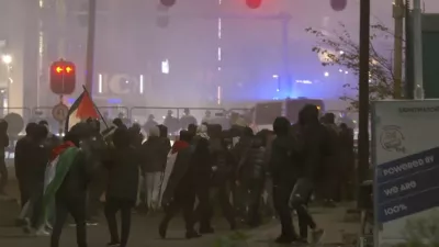 In this image taken from video, a group of pro-Palestinian protesters walk toward police line, with police vans driving in the background, near the soccer stadium in Amsterdam, Netherlands, Thursday, Nov. 7, 2024. (RTL Nieuws via AP)