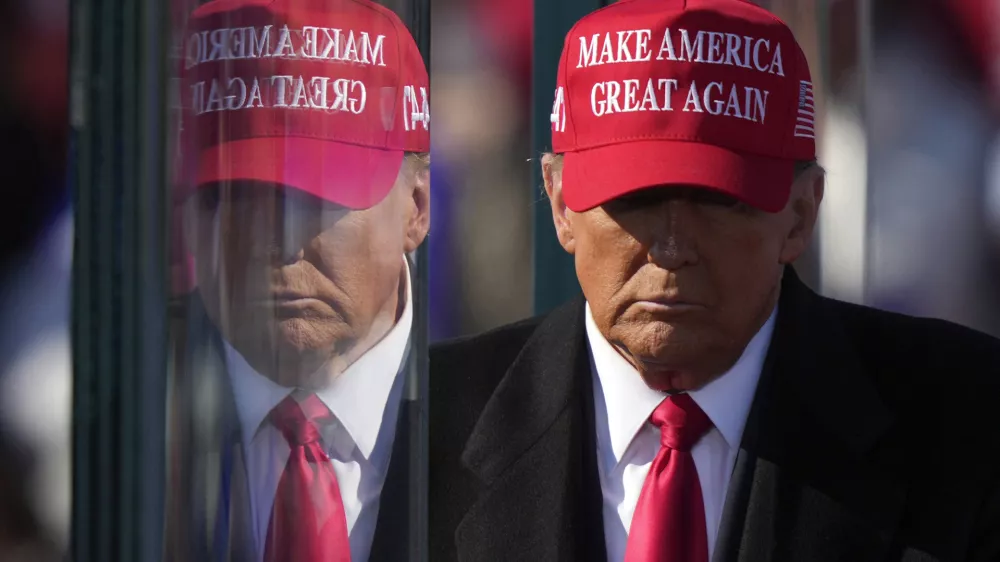 FILE - Republican presidential nominee former President Donald Trump is reflected in the bullet proof glass as he finishes speaking at a campaign rally in Lititz, Pa., Nov. 3, 2024. (AP Photo/Matt Rourke, File)