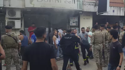 Lebanese soldiers and firefighters gather outside a mobile shop after what is believed to be the result of a walkie-talkie exploding inside it, in the southern port city of Sidon, Lebanon, Wednesday, Sept. 18, 2024. (AP Photo/Mohammed Zaatari)