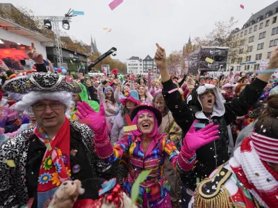 Costumed revelers celebrate at the central Heumarkt while tens of thousands of carnival fools take to the streets of Cologne, Germany, Monday, November 11, 2024, heralding the official start of the carnival season. (AP Photo/Martin Meissner)