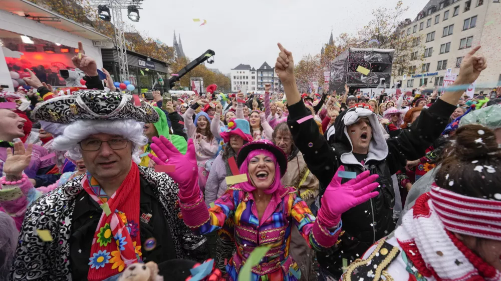 Costumed revelers celebrate at the central Heumarkt while tens of thousands of carnival fools take to the streets of Cologne, Germany, Monday, November 11, 2024, heralding the official start of the carnival season. (AP Photo/Martin Meissner)