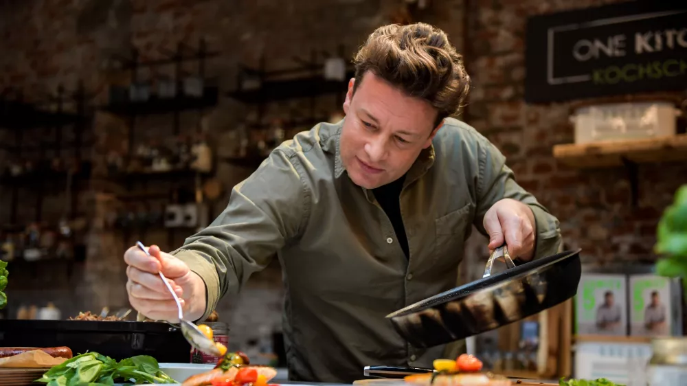 FILED - 06 December 2017, Hamburg: The British chef Jamie Oliver cooks at the One Kitchen Culinary School in Hamburg. Photo: picture alliance / Axel Heimken/dpa