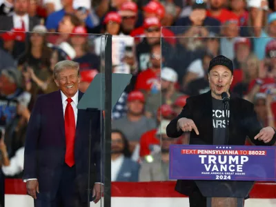 FILE PHOTO: Tesla CEO and X owner Elon Musk speaks as Republican presidential nominee and former U.S. president Donald Trump reacts during a rally at the site of the July assassination attempt against Trump, in Butler, Pennsylvania, U.S., October 5, 2024. REUTERS/Carlos Barria/File Photo