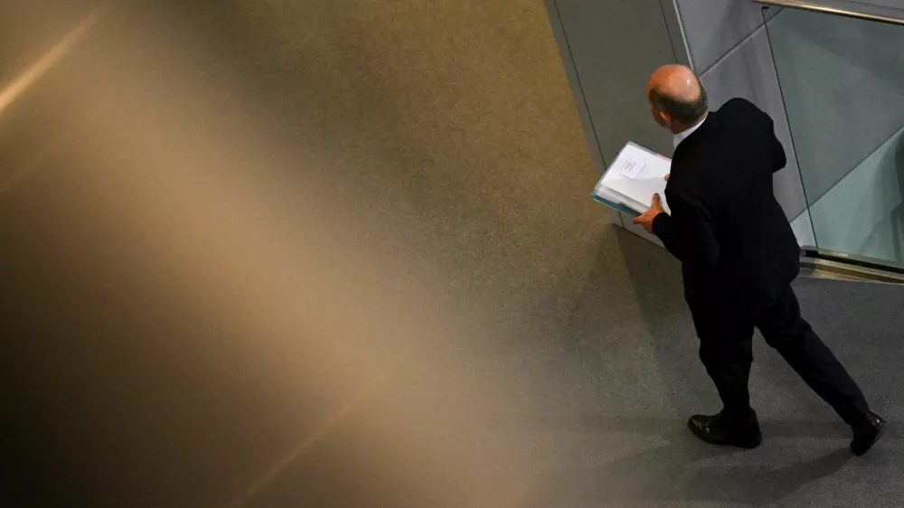 Kancler Scholz zapušča bundestag po govoru, s katerim je udaril pečat na predčasne volitve 23. februarja. Foto: Reuters