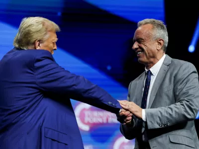 FILE PHOTO: Robert F. Kennedy Jr. and Republican presidential candidate and former U.S. President Donald Trump greet each other at a campaign event sponsored by conservative group Turning Point USA, in Duluth, Georgia, U.S., October 23, 2024. REUTERS/Carlos Barria/File Photo/File Photo