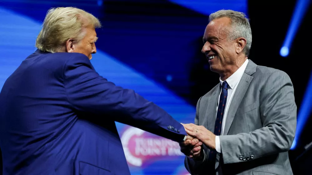 FILE PHOTO: Robert F. Kennedy Jr. and Republican presidential candidate and former U.S. President Donald Trump greet each other at a campaign event sponsored by conservative group Turning Point USA, in Duluth, Georgia, U.S., October 23, 2024. REUTERS/Carlos Barria/File Photo/File Photo