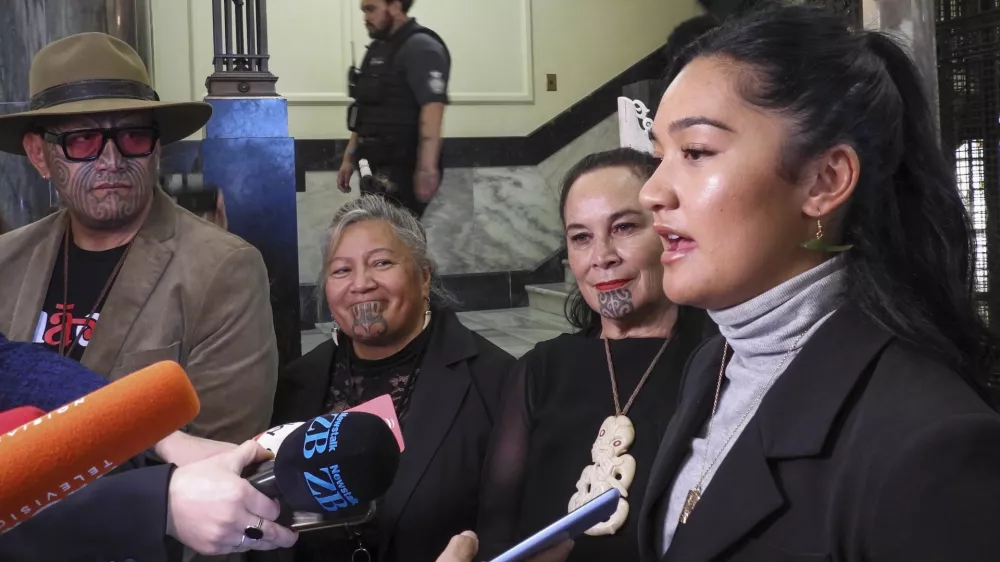 Hana-Rawhiti Maipi-Clarke, right, and her colleagues from Te Haiti Māori, talk to reporters following a protest inside Parliament in Wellington, New Zealand, Thursday, Nov. 14, 2024. (AP Photo/Charlotte Graham-McLay)