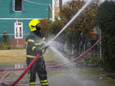 An Indian firefighter works to extinguish a fire on a school building in Srinagar, Indian controlled Kashmir, Thursday, Nov 14, 2024. (AP Photo/Mukhtar Khan)