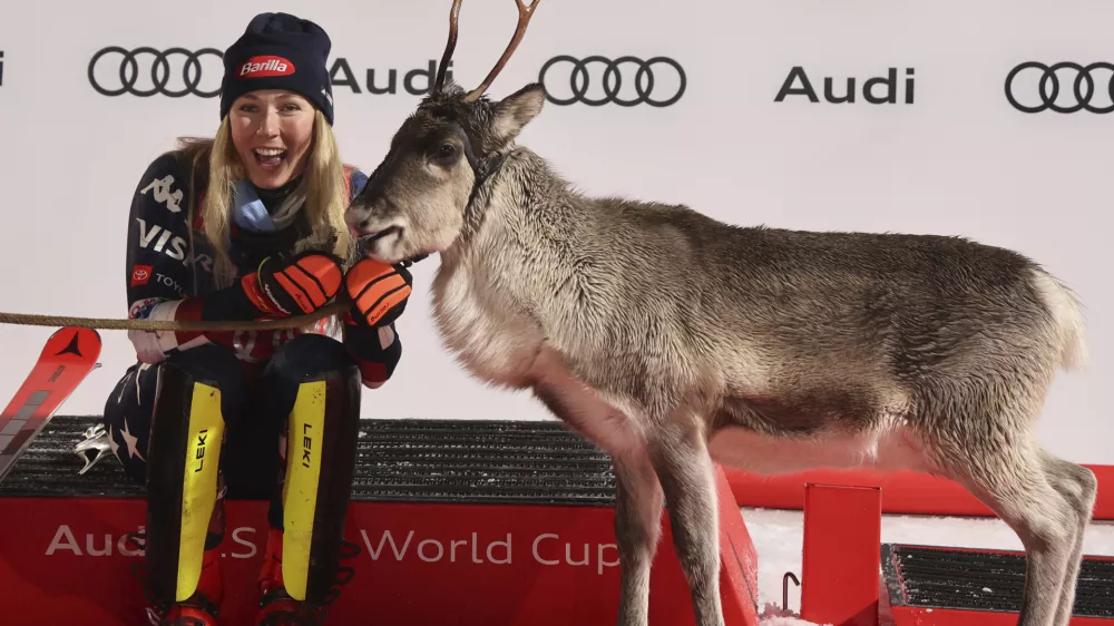 The winner United States' Mikaela Shiffrin shares the podium with a baby reindeer after an alpine ski, women's World Cup slalom, in Levi, Finland, Saturday, Nov. 16, 2024. (AP Photo/Marco Trovati)