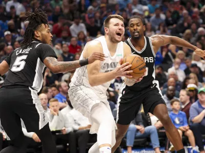 Nov 16, 2024; Dallas, Texas, USA; Dallas Mavericks guard Luka Doncic (77) shoots as San Antonio Spurs guard Stephon Castle (5) and San Antonio Spurs forward Harrison Barnes (40) defend during the second half at American Airlines Center. Mandatory Credit: Kevin Jairaj-Imagn Images