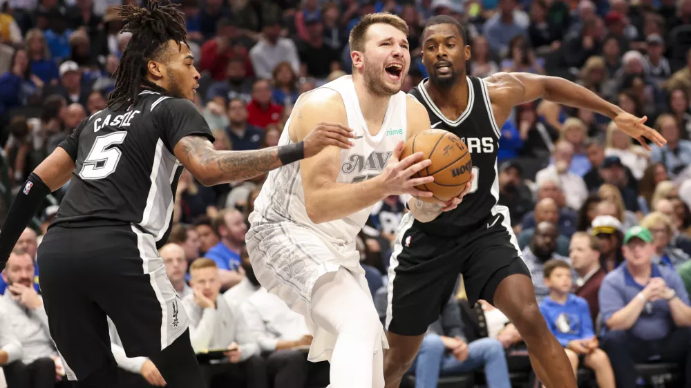 Nov 16, 2024; Dallas, Texas, USA; Dallas Mavericks guard Luka Doncic (77) shoots as San Antonio Spurs guard Stephon Castle (5) and San Antonio Spurs forward Harrison Barnes (40) defend during the second half at American Airlines Center. Mandatory Credit: Kevin Jairaj-Imagn Images