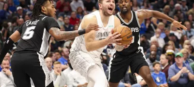 Nov 16, 2024; Dallas, Texas, USA; Dallas Mavericks guard Luka Doncic (77) shoots as San Antonio Spurs guard Stephon Castle (5) and San Antonio Spurs forward Harrison Barnes (40) defend during the second half at American Airlines Center. Mandatory Credit: Kevin Jairaj-Imagn Images