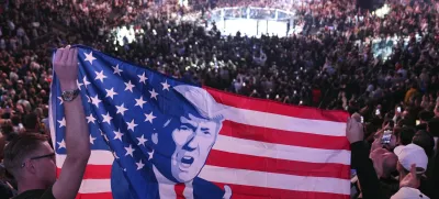 People hold a flag as President-elect Donald Trump arrives at UFC 309 at Madison Square Garden, Saturday, Nov. 16, 2024, in New York. (AP Photo/Evan Vucci)