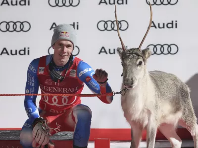 The winner France's Clement Noel celebrates on podium with a young reindeer after an alpine ski, men's World Cup slalom, in Levi, Finland, Sunday, Nov. 17, 2024. (AP Photo/Marco Trovati)