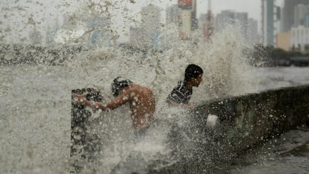 Children play near strong waves from the Pasig River amid Super Typhoon Man-yi, in Manila, Philippines, November 17, 2024. REUTERS/Lisa Marie David