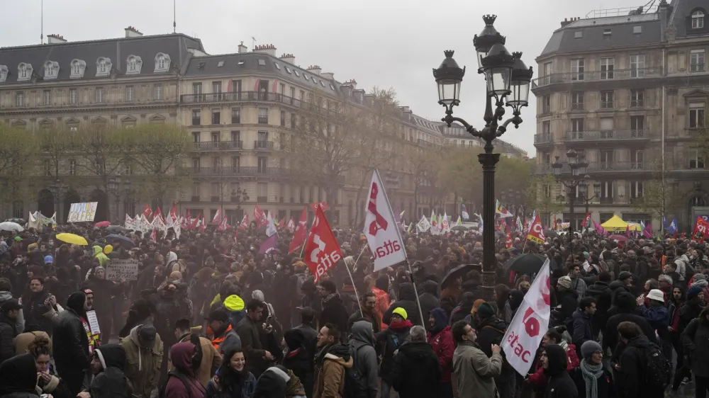 Demonstrators gather outside the Paris town hall, Friday, April 14, 2023 in Paris. France's Constitutional Council on Friday approved an unpopular plan to raise the retirement age to 64, in a victory for French President Emmanuel Macron after three months of mass protests over the legislation that have damaged his leadership. The move is likely to enrage unions and other opponents of the pension plan, including protesters gathered in spots around France on Friday evening as the decision came down.(AP Photo/Lewis Joly)