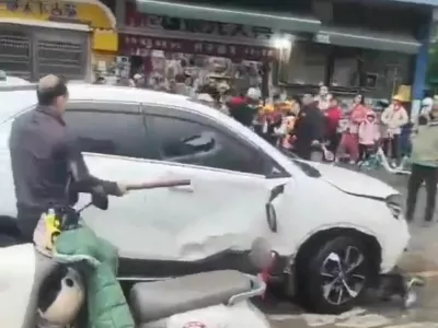 A man breaks a car's window following a vehicle collision outside a primary school in Changde, Hunan province, China in this screengrab obtained from social media video released November 19, 2024. Local authorities have not released any details on the collision. Social Media/via REUTERS THIS IMAGE HAS BEEN SUPPLIED BY A THIRD PARTY. MANDATORY CREDIT. NO RESALES. NO ARCHIVES.