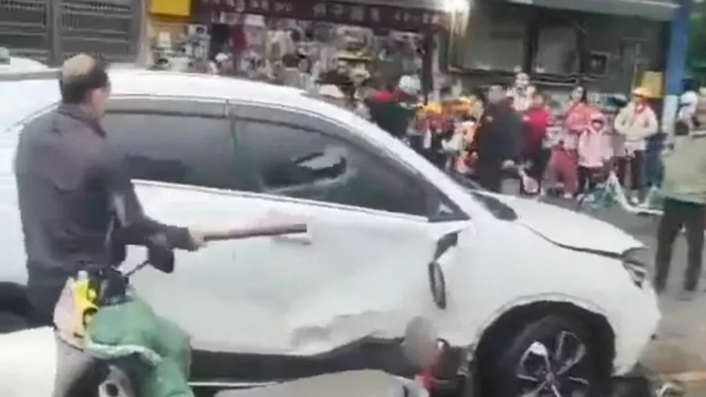 A man breaks a car's window following a vehicle collision outside a primary school in Changde, Hunan province, China in this screengrab obtained from social media video released November 19, 2024. Local authorities have not released any details on the collision. Social Media/via REUTERS THIS IMAGE HAS BEEN SUPPLIED BY A THIRD PARTY. MANDATORY CREDIT. NO RESALES. NO ARCHIVES.