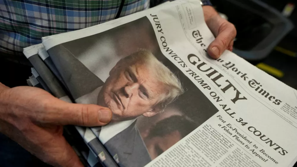 A person holds New York Times newspapers, as they are being printed, following the announcement of the verdict on former U.S. President Donald Trump's criminal trial, over charges that he falsified business records to conceal money paid to silence adult film star Stormy Daniels in 2016, at the New York Times College Point Printing Plant in Queens, New York City, U.S. May 30, 2024. REUTERS/Stephani Spindel   TPX IMAGES OF THE DAY