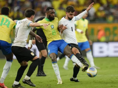 Brazil's Gerson, center, Uruguay's Rodrigo Bentancur, right, and Uruguay's Facundo Pellistri battle for the ball during a qualifying soccer match for the FIFA World Cup 2026 at Arena Fonte Nova in Salvador, Brazil, Tuesday, Nov.19, 2024. (AP Photo/Andre Penner)