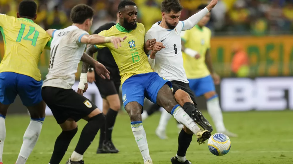 Brazil's Gerson, center, Uruguay's Rodrigo Bentancur, right, and Uruguay's Facundo Pellistri battle for the ball during a qualifying soccer match for the FIFA World Cup 2026 at Arena Fonte Nova in Salvador, Brazil, Tuesday, Nov.19, 2024. (AP Photo/Andre Penner)