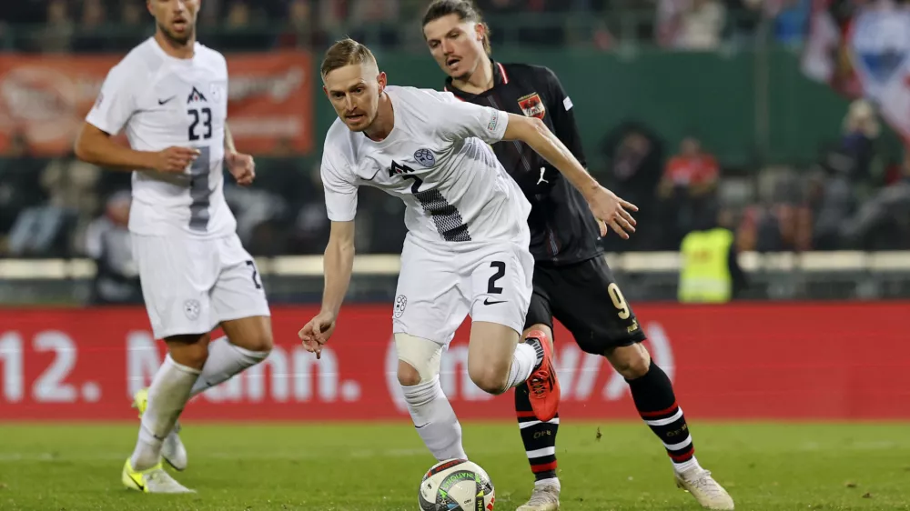 Soccer Football - Nations League - Group Stage - Austria v Slovenia - Ernst Happel Stadion, Vienna, Austria - November 17, 2024 Slovenia's Zan Karnicnik in action with Austria's Marcel Sabitzer REUTERS/Lisa Leutner