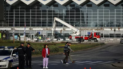 People walk by as a rescue team inspects the area where a part of a roof of a railway station collapsed in Novi Sad, Serbia November 2, 2024. REUTERS/Marko Djurica