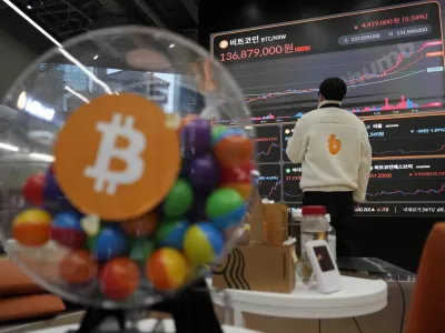 An employee watches an electronic signboard displaying the prices of Bitcoin and other cryptocurrencies at the lounge of Bithumb cryptocurrency exchange in Seoul, South Korea, Thursday, Nov. 21, 2024. (AP Photo/Ahn Young-joon)