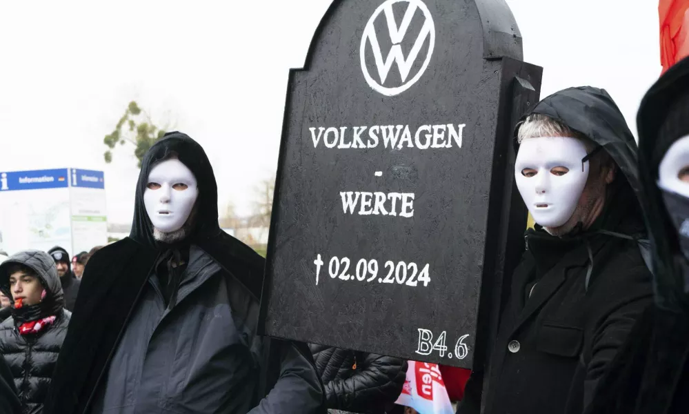 Volkswagen employees demonstrate in front of the Volkswagen Arena in Wolfsburg during the wage negotiations between Volkswagen and IG Metall, Tursday, Nov. 21, 2024. (Alicia Windzio/dpa via AP)