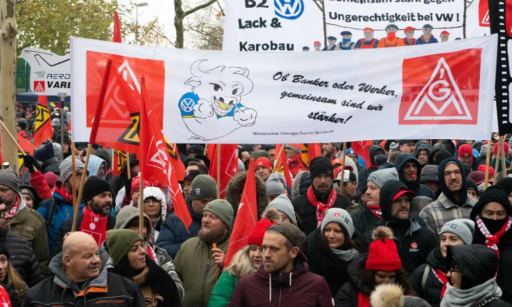 21 November 2024, Lower Saxony, Wolfsburg: Volkswagen employees demonstrate in front of the Volkswagen Arena in Wolfsburg during the wage negotiations between Volkswagen and IG Metall. IG Metall welcomes the Group representatives to the third round of collective bargaining with a loud protest. Photo: Alicia Windzio/dpa